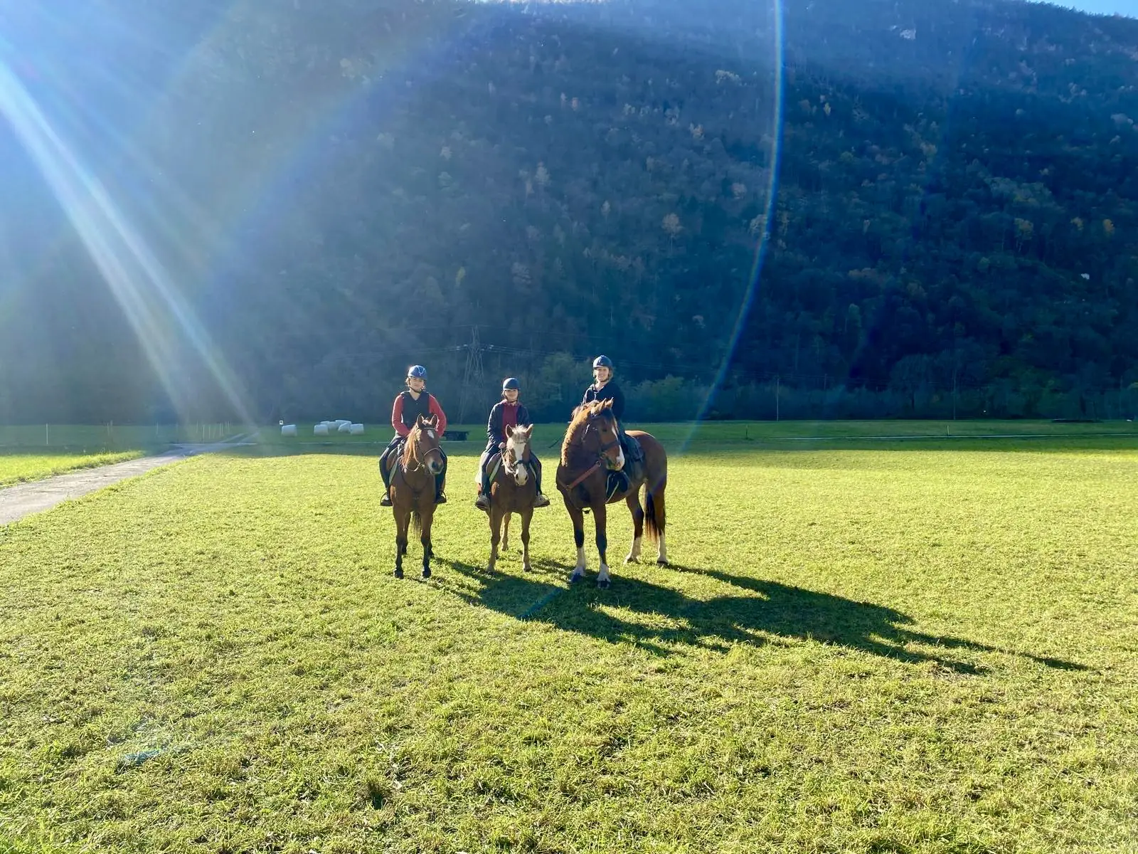 Tre allievi a cavallo, fermi in fila sul campo in erba a Biasca